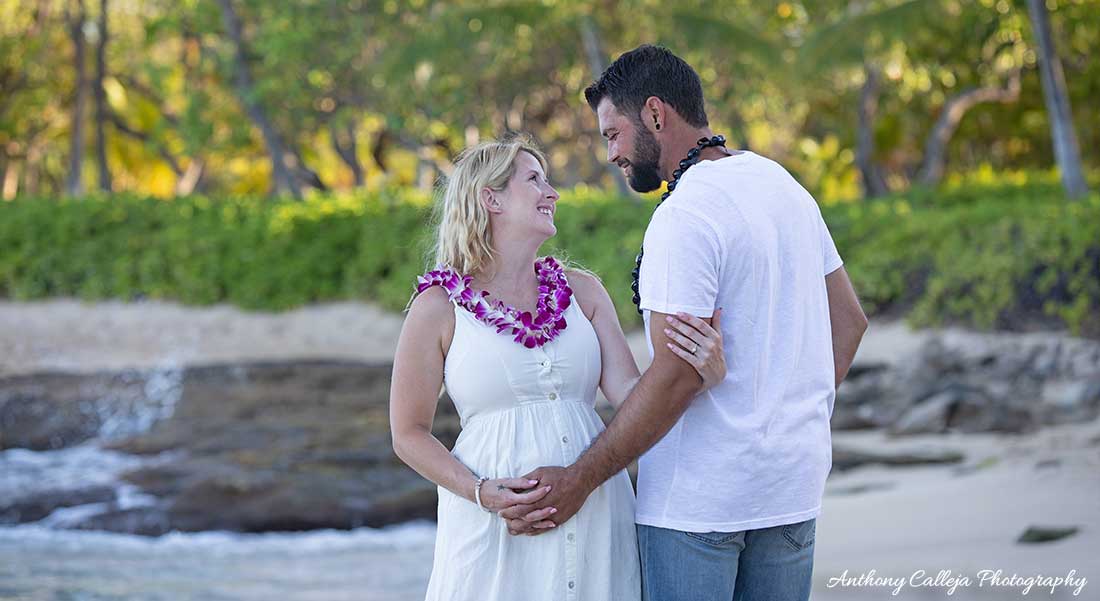 Maternity Couple holding hands looking into each others eyes at Secret Beach, KoOlina, Oahu, Hawaii