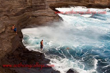 Cliff Jumpers observe the spay at Spitting Cave of Portlock, Oahu, Hawaii