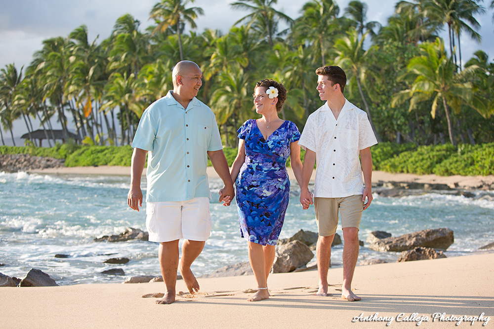 Oahu Family Photography Session - Family of three, holding hands walking on the sand at Secret Beach Koolina
