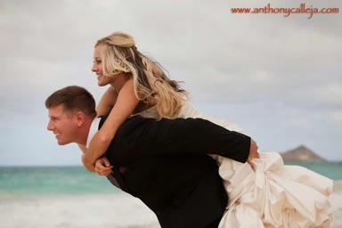 Honolulu Wedding Photography - Groom giving the bride a piggy back ride at Waimanalo beach